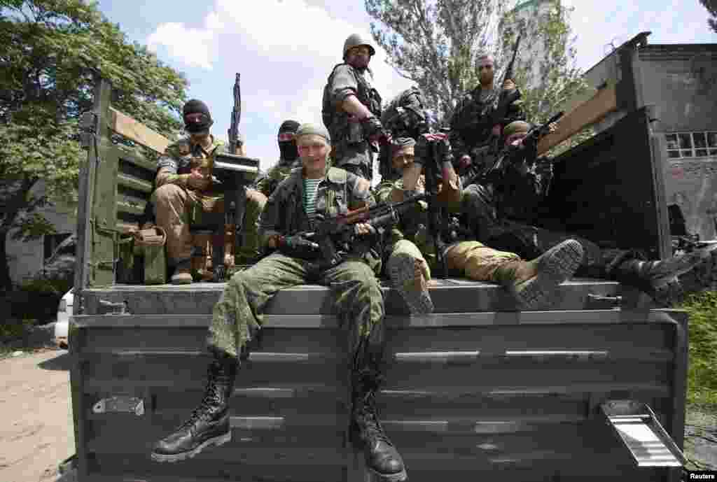 Pro-Russian separatist fighters from the so-called Battalion Vostok (East) sit in a truck as they leave a base in the eastern Ukrainian city of Donetsk, July 10, 2014. 