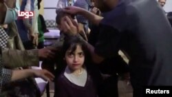 A girl looks on following alleged chemical weapons attack, in what is said to be Douma, Syria in this still image from video obtained by Reuters. (April 8, 2018.)