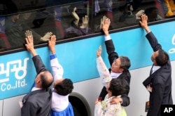 South Koreans on a bus touch the bus window in their attempt to feel the hands of their North Korean relatives as they bid farewell after the Separated Family Reunion Meeting at Diamond Mountain resort in North Korea, Monday, Oct. 26, 2015.