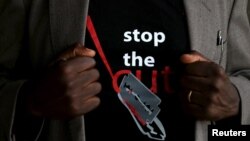 FILE - A man's T-shirt reads "Stop the Cut" referring to Female Genital Mutilation during a social event advocating against such harmful practices at the Imbirikani Girls High School in Imbirikani, Kenya, April 21, 2016.