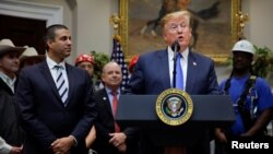 U.S. President Donald Trump speaks next to Federal Communications Commission Commissioner Ajit Pai during an event on U.S. 5G deployment in the Roosevelt Room of the White House in Washington, April 12, 2019. 