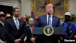 U.S. President Donald Trump speaks next to Federal Communications Commission (FCC) Commissioner Ajit Pai during an event on United States 5G deployment in the Roosevelt Room of the White House in Washington, April 12, 2019. 