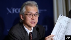Joji Morishita, Japan's commissioner to the International Whaling Commission (IWC), holds documents as he speaks about Japan's whaling program during a press conference in Tokyo, Nov. 28, 2014. 