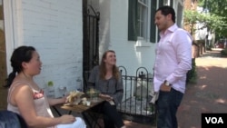 Falafel Inc. owner Ahmad Ashkar talks with customers outside the shop in Washington's Georgetown neighborhood. (J.Soh/VOA)