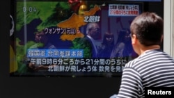 一名男子2019年5月4日在东京街头观看朝鲜发射数枚短程飞行器的电视新闻。