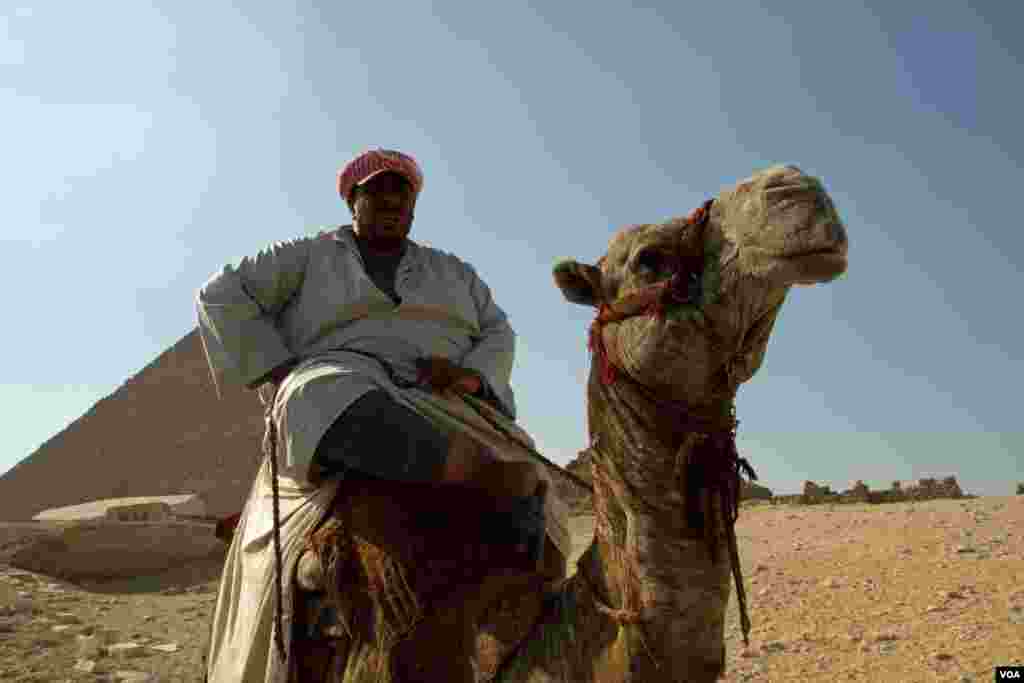 A man sits on his camel in front of the Pyramids at Giza, Egypt, July 13, 2013. (A. Arabasadi/VOA) 