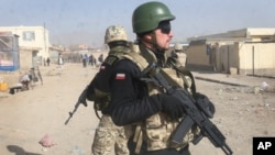 FILE - Polish NATO soldiers are seen patrolling in Ghazni, west of Kabul, Afghanistan, Dec. 21, 2011. Polish and Afghan special forces, backed by U.S. air power, freed 11 hostages held by the Taliban in Afghanistan's Helmand province, Poland's defense minister announced Tuesday.