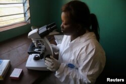 A laboratory worker uses a microscope at the health center in the commune of Wangata during a vaccination campaign against the outbreak of Ebola, in Mbandaka, Democratic Republic of the Congo, May 23, 2018.