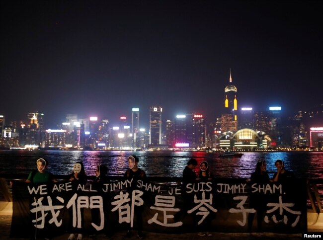 抗议者面罩岑子杰的面具手举标语在香港举行示威。（2019年10月18日）