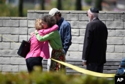 Synagogue members console one another outside of the Chabad of Poway Synagogue, April 27, 2019, in Poway, California.