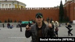 A man identified as Tajik Alan Chekranov holding a pistol and extending one finger -- a common sign used by Islamist militants to mean "one," an attestation of belief in tawhid, or monotheism -- at Red Square in Moscow, possibly in 2012.