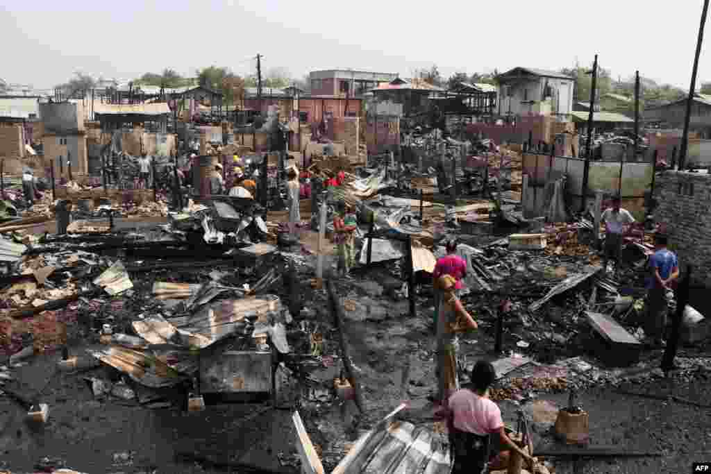 Residents inspect burned ruins after an overnight fire that engulfed over 100 houses in Mandalay, Myanmar as the country continues to be in turmoil after the February military coup.