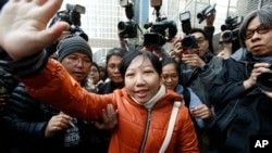 Indonesian maid Erwiana Sulistyaningsih, center, waves to her supporters as she arrives at a court in Hong Kong, Feb. 10, 2015.