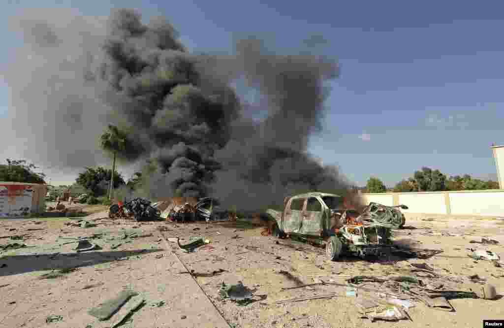 A car burns after a bomb exploded inside it near a school where a training workshop for municipal council elections was being held, in Benghazi, Libya.