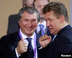 Rosneft CEO Igor Sechin (L) and Alexei Miller, the head of Russian gas giant Gazprom, chat as they wait for the address by Russian President Vladimir Putin at the international businessmen gathering ahead of a summit of leaders of the 21-member Asia-Pacif