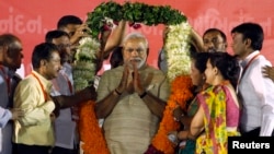 Hindu nationalist Narendra Modi, who will be the next prime minister of India, wears a garland presented to him by his supporters at a public meeting in the western Indian city of Ahmedabad, May 20, 2014