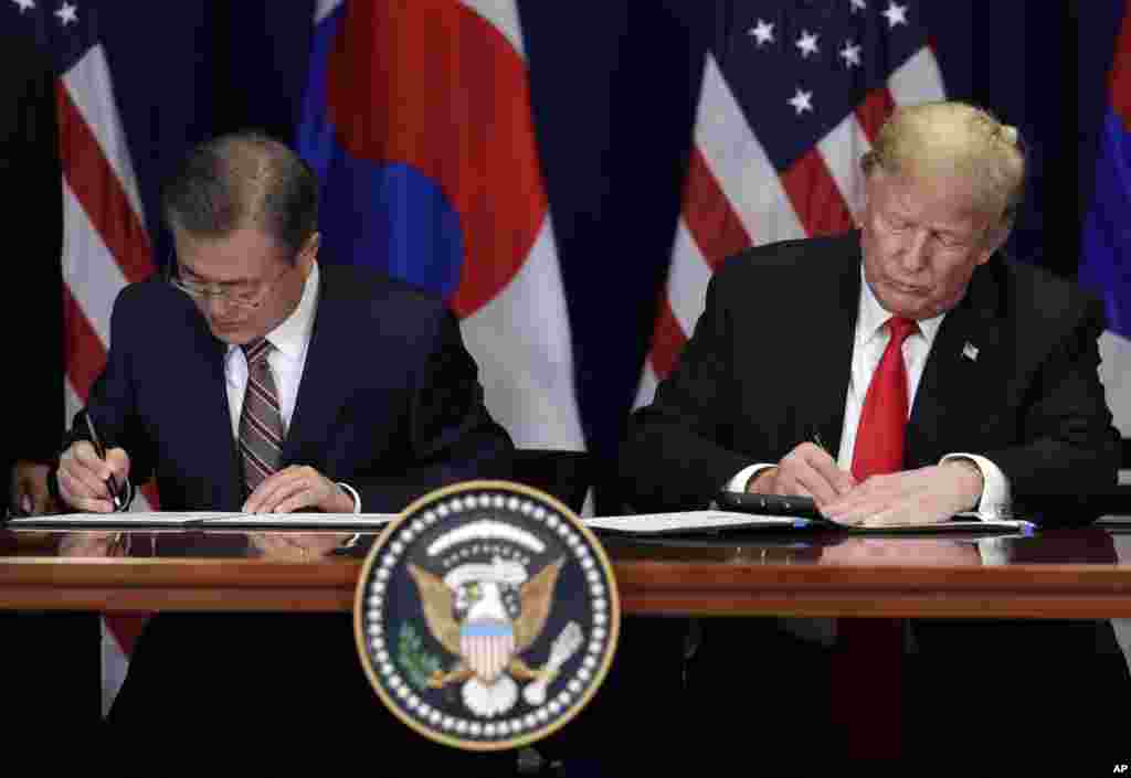 도널드 트럼프 미국 대통령과 문재인 한국 대통령이 정상회담을 마친 후 한미 FTA 개정안에 서명하고 있다.