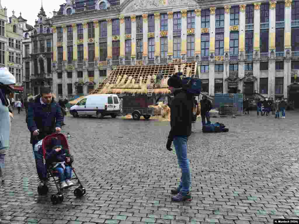 Amid the fear, Brussels continues to prepare for Christmas, as workers build a manger in the square. Local hotels, however, have been asked to keep their doors locked and many shops, cinemas, and train lines are closed.