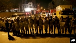 FILE - Iranian security stand guard to protect Saudi Arabia's embassy in Tehran, Iran, while a group of demonstrators gathered to protest execution of a Shi'ite cleric in Saudi Arabia, Jan. 3, 2016.