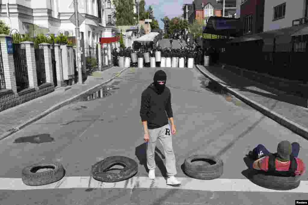 An activist from a pro-Ukrainian radical youth group stands in a front of riot police outside the Russian embassy in Kyiv, June 22, 2014.