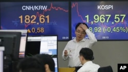 Currency traders work at the foreign exchange dealing room of the KEB Hana Bank headquarters in Seoul, South Korea, Friday, Sept. 18, 2015.