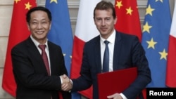 President of Airbus Commercial Aircraft, Guillaume Faury, and Chairman of China Aviation Supplies Co., Jia Baojun, shake hands during an agreement signing ceremony at the Elysee Palace in Paris, March 25, 2019. 