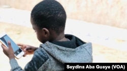 Un enfant sénégalais avec un téléphone portable, à Dakar, le 18 novembre 2021. 