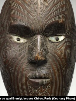 Koruru or Parata (Māori gable mask), New Zealand 19th century, made of carved wood, white pigment, pāua (abalone) shell. The mask show examples of tā moko (Māori tattoo). The intricate patterns represent an individual's accomplishments, genealogy, and social standing.