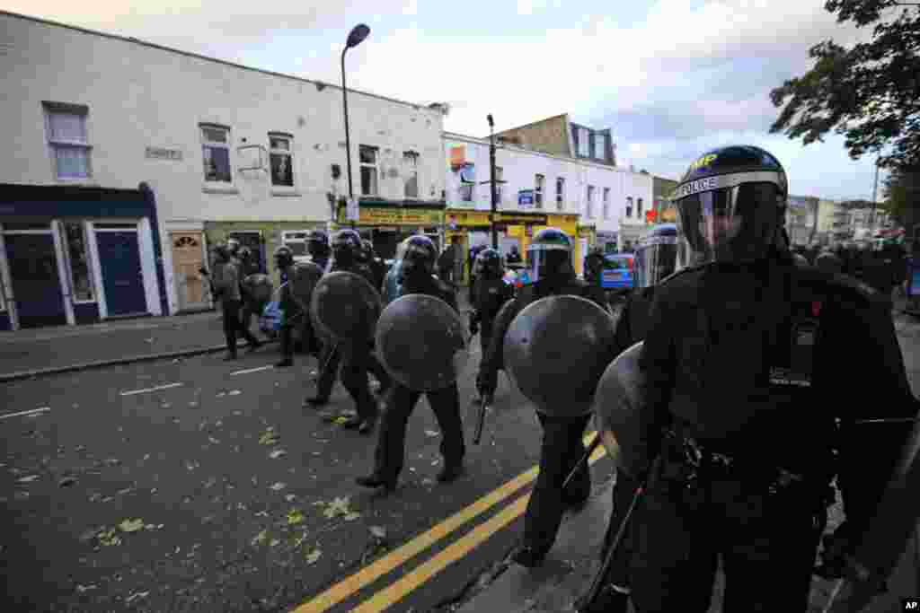 British police officers charge rioters, during riots in Hackney, east London, Monday Aug. 8, 2011. Youths set fire to shops and vehicles in a host of areas of London _ which will host next summer's Olympic Games _ and clashed with police in the nation's c