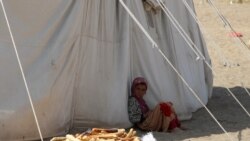 Devojčica sedi ispred šatora u kampu al-Vara za interno raseljene, u provinciji Hodeida u Jemenu, 21. novembra 2021.
