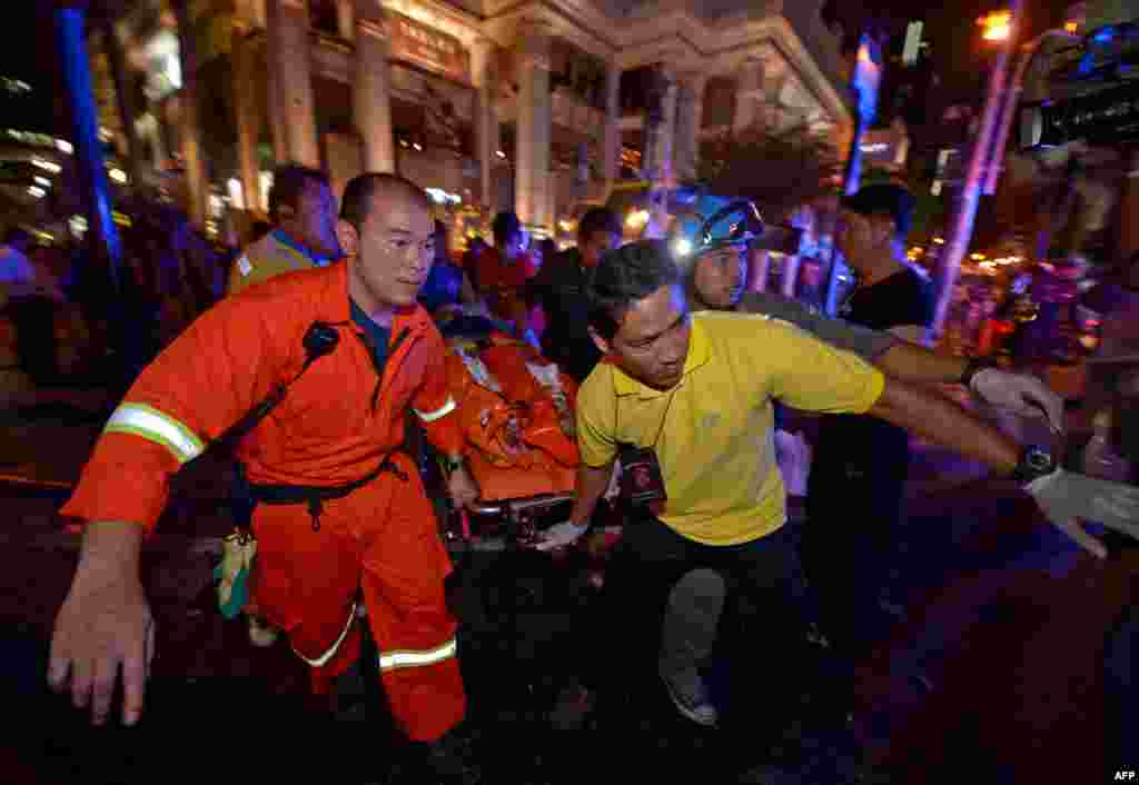 Pekerja penyelamat Thailand membawa korban luka dalam ledakan bom hari Senin (17/8) di dekat sebuah kuil di pusat kota Bangkok.