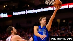 Dallas Mavericks' Dirk Nowitzki (41) goes for a layup against the Chicago Bulls' Pau Gasol (16) during the second half of an NBA preseason basketball game in Lincoln, Neb., Friday, Oct. 23, 2015. 