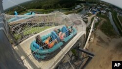 FILE - In this photo taken with the fisheye lens, riders go down the world's tallest water slide called "Verruckt" at Schlitterbahn Waterpark in Kansas City, Kan., July 9, 2014. The ride will be demolished following the death of a boy in August 2016.