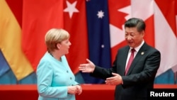 FILE - Chinese President Xi Jinping talks with German Chancellor Angela Merkel as they pose for a group picture during the G20 Summit in Hangzhou, Zhejiang province, China September 4, 2016.