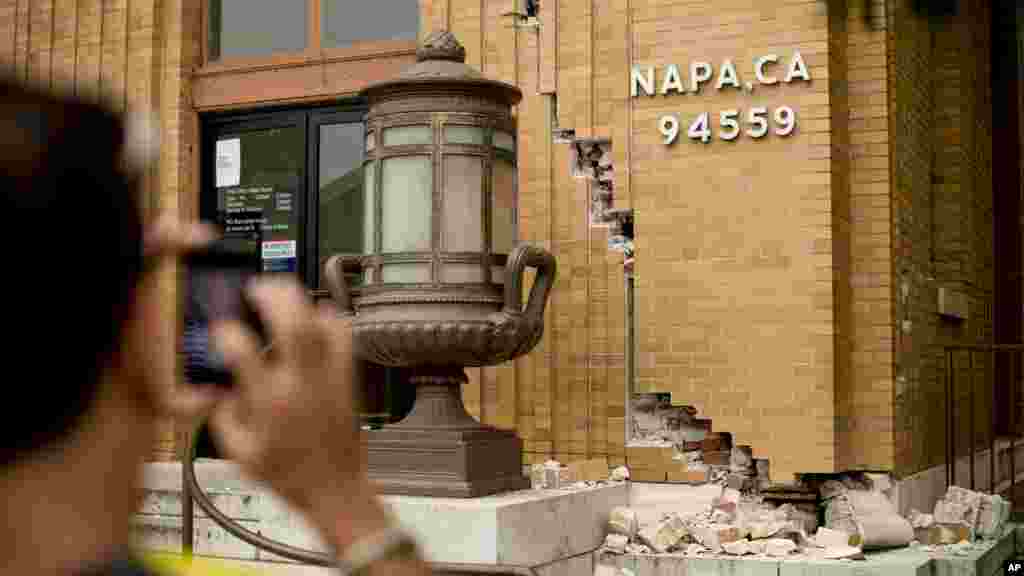 A man photographs damage to a post office in Napa, Calif., following an earthquake, Aug. 24, 2014. 