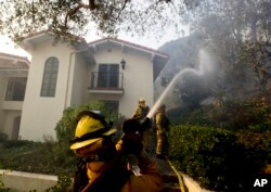 Firefighters from Kern County, Calif., work to put out hot spots, Dec. 16, 2017, in Montecito, Calif.