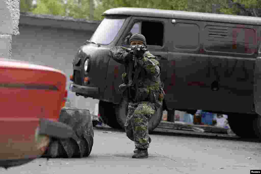 A pro-Russian rebel aims his rifle at a checkpoint near a Ukrainian airbase in Kramatorsk, eastern Ukraine May 2, 2014.