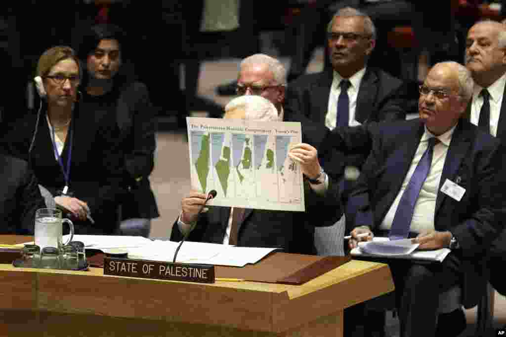 Palestinian President Mahmoud Abbas holds up a document as he speaks during a Security Council meeting at United Nations headquarters.