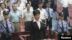 Gu Kailai (C), wife of ousted Chinese politician Bo Xilai, stands at the defendant's dock during her trial at Hefei Intermediate People's Court in this still image taken from video, August 20, 2012. 