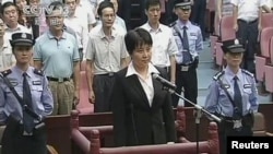 Gu Kailai (C), wife of ousted Chinese Communist Party Politburo member Bo Xilai, stands at the defendant's dock during a trial in the court room at Hefei Intermediate People's Court in this still image taken from video, August 20, 2012. 