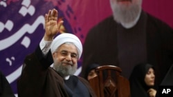 FILE - Iranian President Hassan Rouhani waves to his supporters in a campaign rally for the May 19 presidential election in Tehran, Iran, May 9, 2017.