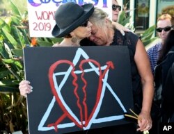 Leslie Gollub, left, and Gretchen Gordon hug at a vigil held to support the victims of Saturday's shooting at Chabad of Poway synagogue, Sunday, April 28, 2019, in Poway, Calif.