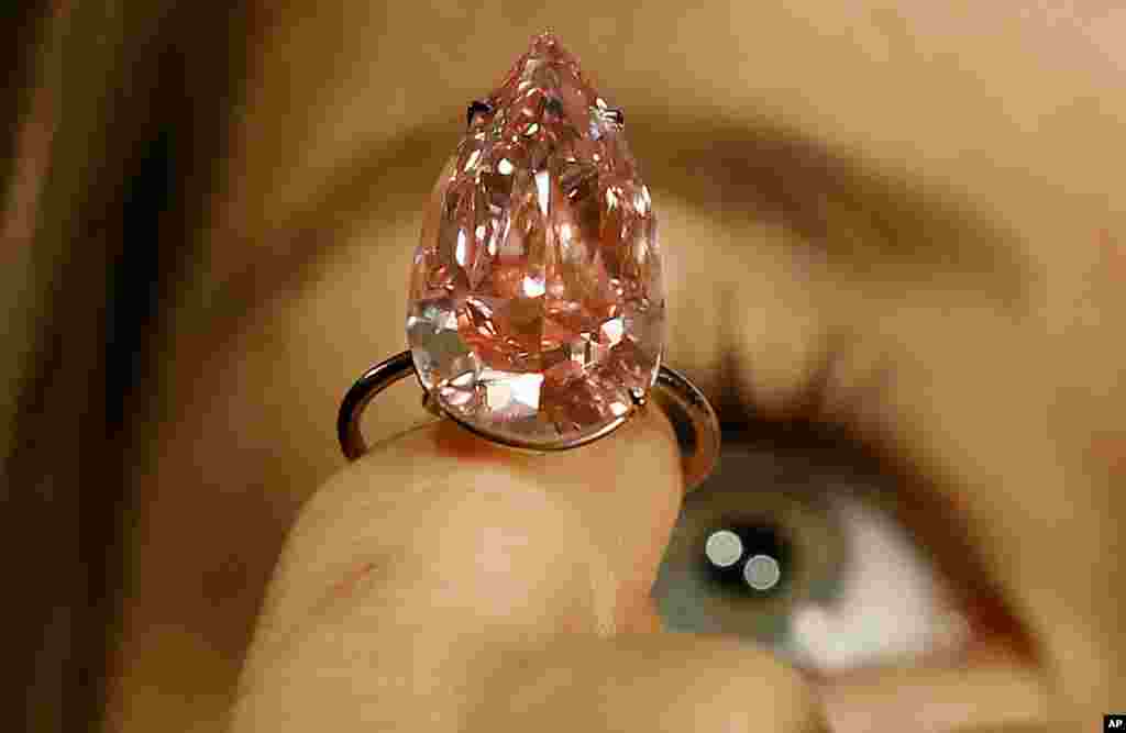 영국 런던 소더비 경매에서 한 모델이 세계에서 가장 큰 눈물 모양 비비드 핑크 다이아몬드인 '유니크 핑크'를 들고 있다.