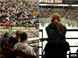 Volunteers and students excitedly watching the hockey game