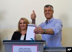Kosovo's prime minister, Hashim Thaci, joined by his wife, Lumnije, casts his ballot at a polling station in the Kosovo capital of Pristina, June 8, 2014. K