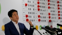 아베 신조 일본 총리가 10일 일본 도쿄 자민당사에 설치된 참의원 선거 상황실에서 개표 현황을 살피며 기자들의 질문에 답하고 있다. 