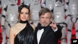 From left, Actors Daisy Ridley (who plays Rey) and Mark Hamill (Luke Skywalker) pose for photographers upon arrival at the premiere of the film 'Star Wars: The Last Jedi' in London, Dec. 12th, 2017.