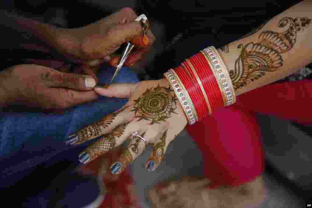 هنر حنا روی دست یک زن جوان در حاشیه فستیوال تیج (Teej) در هند. این مراسم پیام آور فصل باران در هند است.&nbsp;