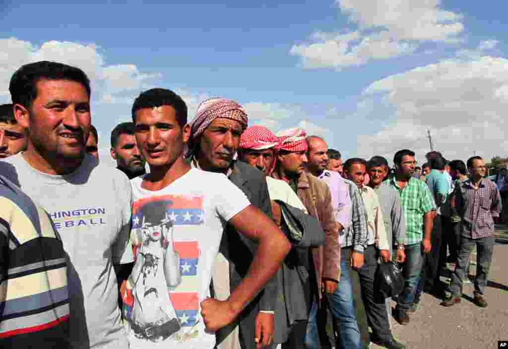 Syrian refugees return home at Mursitpinar crossing gate near Suruc, Turkey, Sept. 25, 2014.