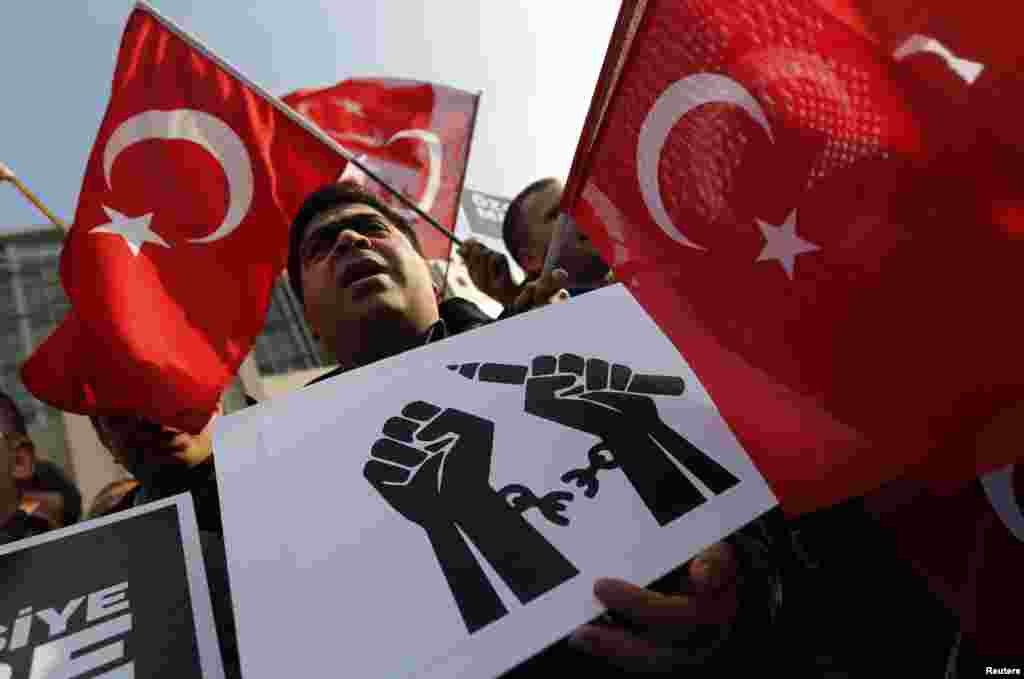 Supporters of the Gulen movement wave Turkish flags as they gather outside the Justice Palace in Istanbul. A Turkish court kept a media executive and three other people in custody on Friday pending trial on accusations of belonging to a terrorist group, in a case which President Tayyip Erdogan has defended as a response to "dirty operations" by his enemies.